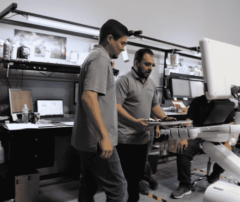 Ultrasound refurbishing technicians installing GE ultrasound keyboard